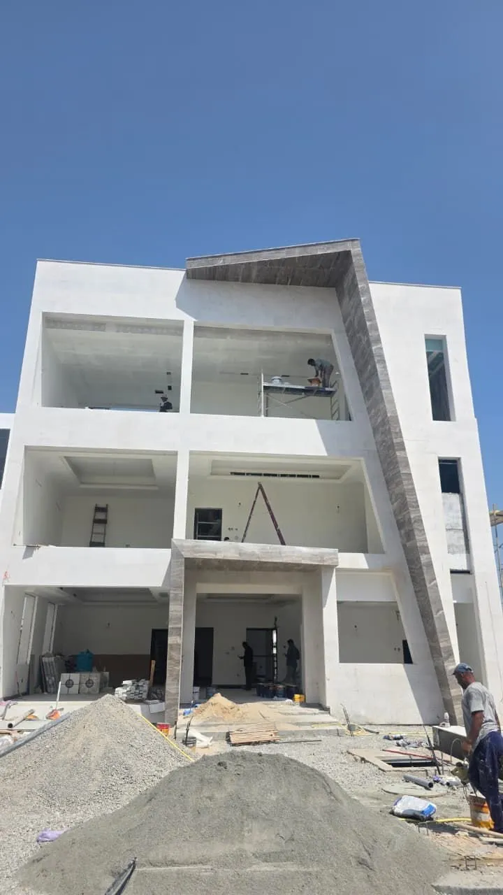 Villa elevation showing the entrance and balcony with crew working