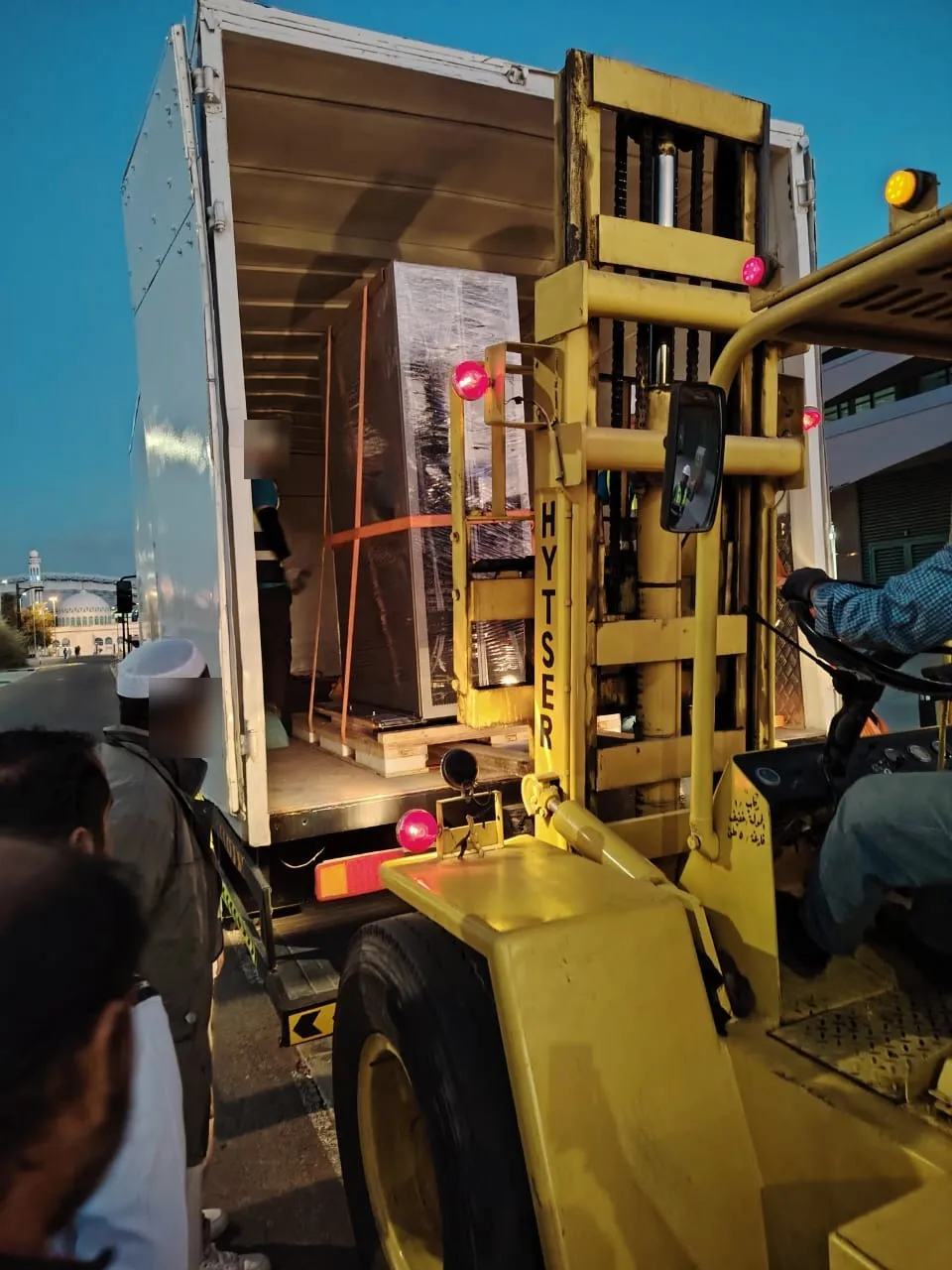 Palletised and wrapped equipment inside a delivery truck at a site entrance