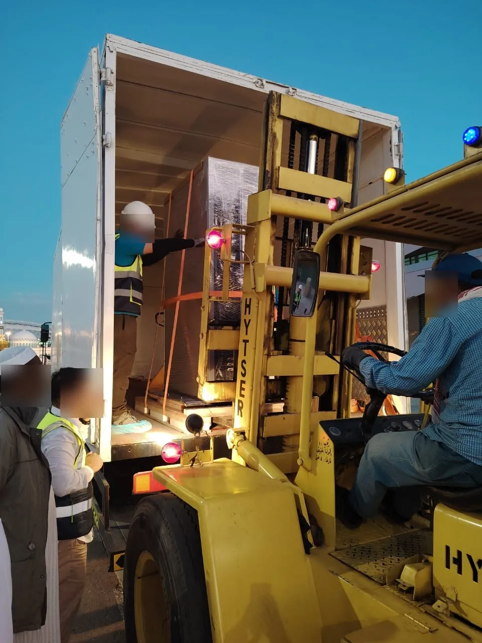 Crated LV equipment being offloaded from a truck by forklift