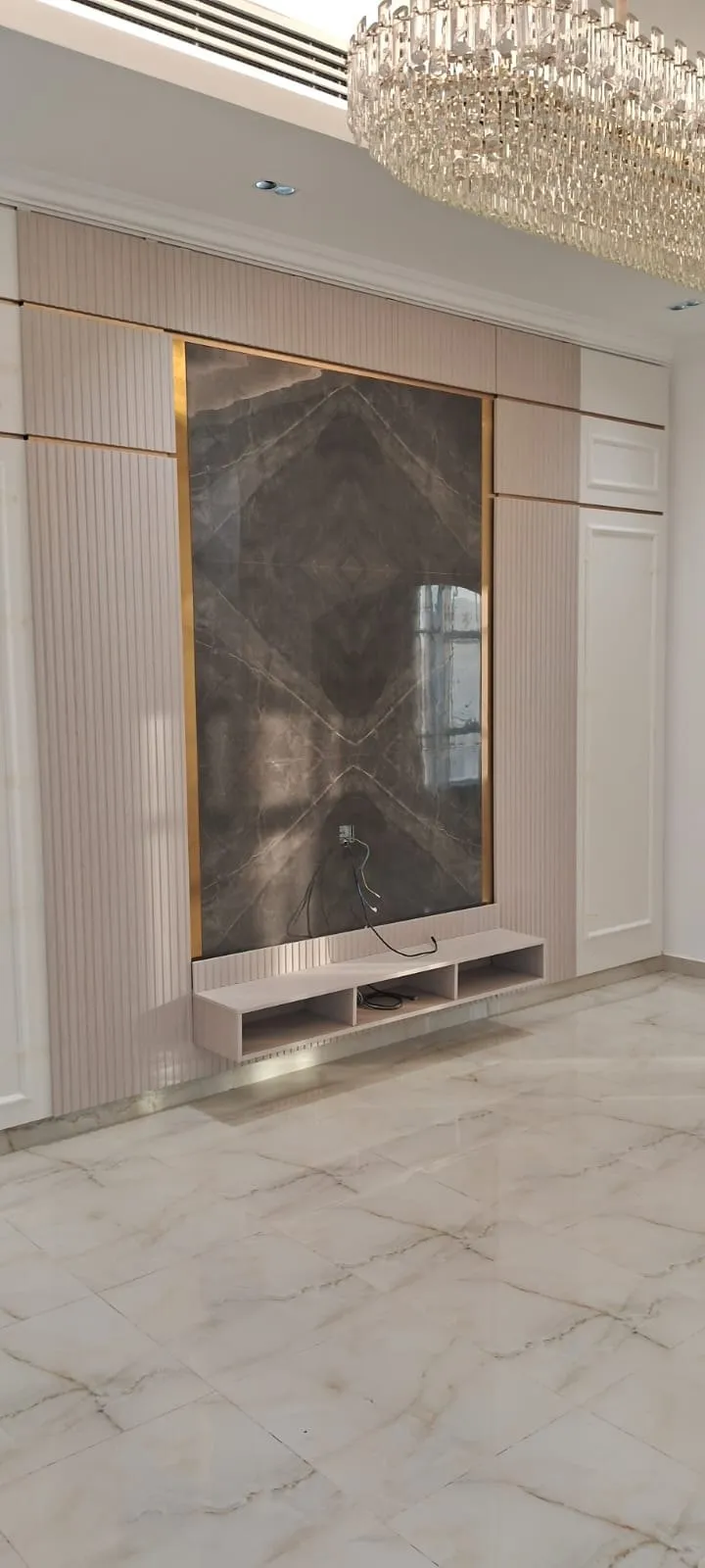 Fluted blush oak feature wall with a gold edged bookmatched marble panel