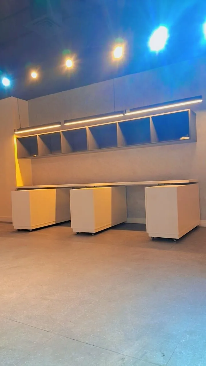 Mobile pedestals beneath open shelving with LED strips and coloured ambient lighting